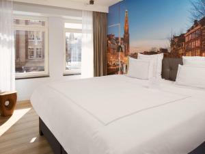 a large white bed in a room with a window at Swissôtel Amsterdam in Amsterdam +172 photos