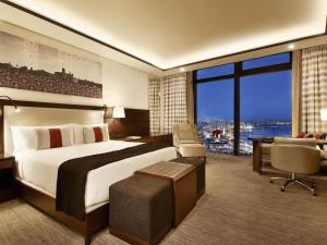 a hotel room with a large bed and a desk at Fairmont Baku, Flame Towers in Baku +146 photos