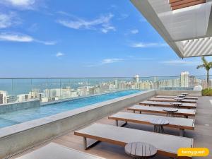 einem Pool auf dem Dach eines Gebäudes mit Bänken in der Unterkunft Beach Class Meireles in Fortaleza