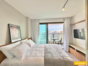 ein Schlafzimmer mit einem großen weißen Bett und einem Balkon in der Unterkunft Beach Class Meireles in Fortaleza + 29 Fotos