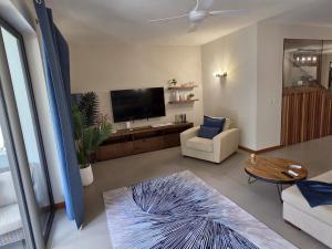 Μια τηλεόραση ή/και κέντρο ψυχαγωγίας στο Chic poolside haven 3BR steps from the beach