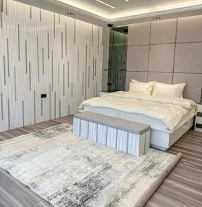 a bedroom with a large bed with a bench next to it at By Sayyar in Abu Dhabi +8 photos