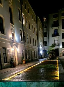 an empty city street at night with buildings at Apartament Plac Zabaw in Łódź