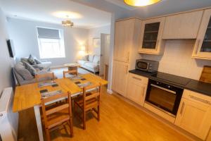 a kitchen and living room with a table and chairs at Stonehaven ground floor home with a spectacular harbour view. in Stonehaven +17 photos