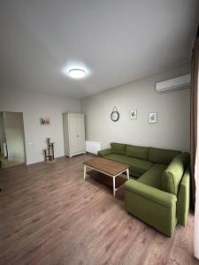 a living room with a green couch and a coffee table at Hotel Kutaisi Globus in Kutaisi +57 photos