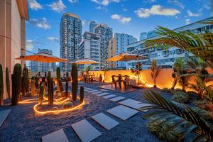 a patio with tables and umbrellas in a city at Chongqing INS·Wanbai Terrace River View Hotel (Jiefangbei Hongyadong Branch) in Nan'an