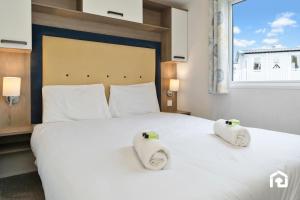 a bedroom with a white bed with two towels on it at Vacant Nests Seton Sands Kings Barns Starlink in Longniddry