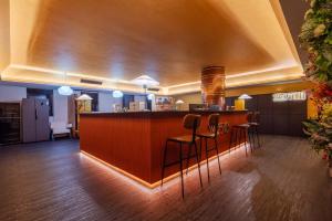 a lobby with a bar with stools and a kitchen at Chongqing INS·Wanbai Terrace River View Hotel (Jiefangbei Hongyadong Branch) in Nan'an +53 photos