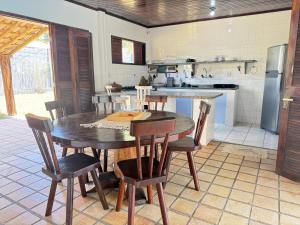 a kitchen with a table and chairs and a refrigerator at Oceana Suites Vila da Mata in Pipa