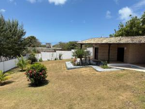 a small house with a yard with a fence at Oceana Suites Vila da Mata in Pipa