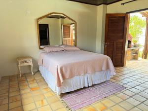 a bedroom with a bed with a mirror on the wall at Oceana Suites Vila da Mata in Pipa +22 photos