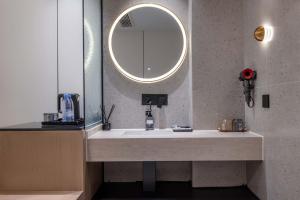 a bathroom with a sink and a mirror at Chongqing INS·Wanbai Terrace River View Hotel (Jiefangbei Hongyadong Branch) in Nan'an
