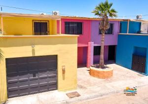 a colorful house with a garage and a palm tree at Condo 3, Easy Walk to San Felipe Malecon in San Felipe