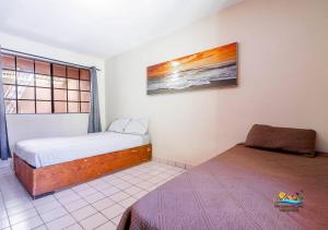 a small bedroom with a bed and a window at Condo 3, Easy Walk to San Felipe Malecon in San Felipe