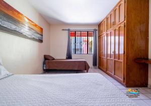 Condo 3, Easy Walk to San Felipe Malecon في سان فيليبي: غرفة نوم بها سرير وكرسي ونافذة +21 صورة