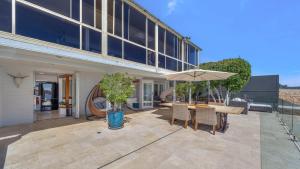 un patio con una mesa y una sombrilla en 'Waterfront Studio' by HolidayCo, en Blackwall 12 fotos más