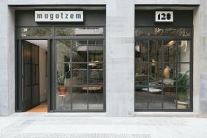 a store front with glass doors with a table inside at Magatzem 128 in Barcelona