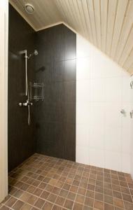 a bathroom with a shower with black and white tiles at Holiday Houses Saimaa Gardens in Imatra