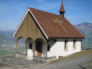 a small church on top of a hill at Biohof Langberg in Lauerz