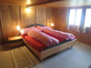a bedroom with a bed with a red comforter at Biohof Langberg in Lauerz +19 photos