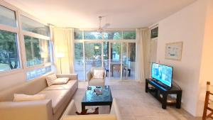 ein Wohnzimmer mit Sofa und Fernseher in der Unterkunft Terrazas de Carilo 1A in Carilo