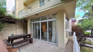 ein Haus mit einer Veranda mit einer Bank auf einer Terrasse in der Unterkunft Terrazas de Carilo 1A in Carilo