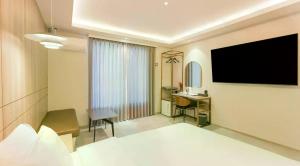 a hotel room with a television and a desk at browndot 서천  +26 photos