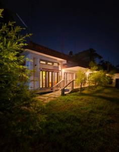 una casa por la noche con las luces encendidas en Minimalistic white stay, en Jorhāt 19 fotos más