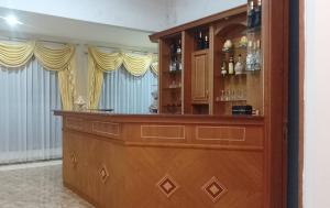 Eine Bar in einem Raum mit Vorhängen und einer Theke in der Unterkunft Sentral Villa Trawas in Trawas