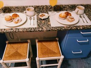 a counter with two plates of pastries and cups of coffee at Encalma Vacacional El Ático in Puerto de Sagunto