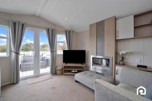a living room with a couch and a television at Vacant Nests The Archerfield Seton Sands in Longniddry