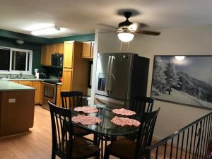 Una cocina con una mesa con sillas y un refrigerador. en your family home, en Aurora