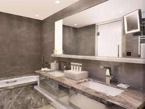 ein Badezimmer mit zwei Waschbecken, einem Spiegel und einer Badewanne in der Unterkunft Swissotel The Bosphorus Istanbul in Istanbul + 183 Fotos