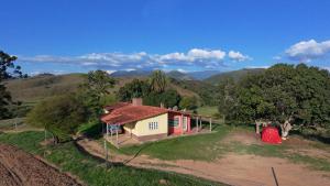 a small house in the middle of a field at Sítio com casa Rústica Itamonte in Santana do Capivari +21 photos