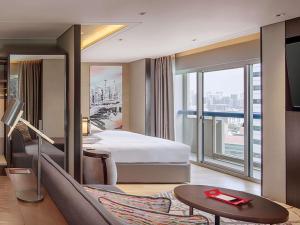 a hotel room with a bed and a large window at Swissotel The Stamford Singapore in Singapore +106 photos