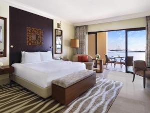 a hotel room with a large bed and a balcony at Fairmont The Palm in Dubai