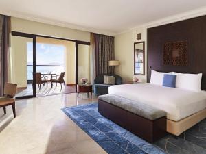 a bedroom with a large bed and a living room at Fairmont The Palm in Dubai