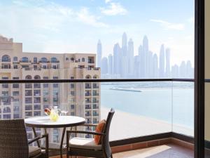 a balcony with a table and chairs and a view of the city at Fairmont The Palm in Dubai +169 photos