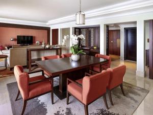 a dining room with a table and red chairs at Fairmont The Palm in Dubai +168 photos