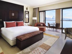a bedroom with a large bed and a living room at Fairmont The Palm in Dubai