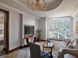 メッカにあるラッフルズ マッカ パレスのソファとテレビのあるリビングルーム