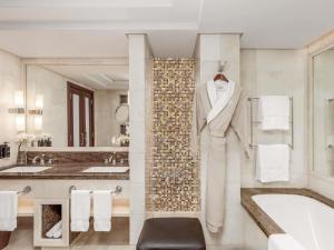 メッカにあるラッフルズ マッカ パレスの壁にバスローブが掛けてあるバスルーム