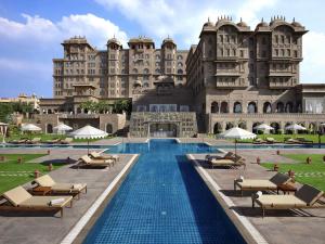 a hotel with a swimming pool in front of a building at Fairmont Jaipur in Jaipur