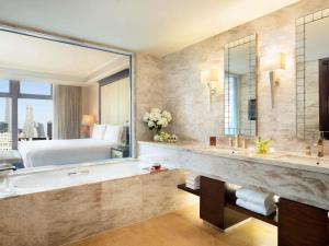 a bathroom with a tub and a large mirror at Fairmont Beijing in Beijing +182 photos