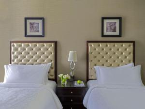 two beds in a hotel room with white sheets at Makkah Clock Royal Tower, A Fairmont Hotel in Makkah