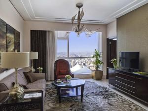 a living room with a couch and a tv at Makkah Clock Royal Tower, A Fairmont Hotel in Makkah