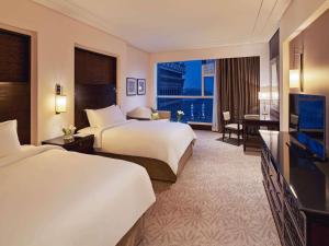 a hotel room with two beds and a television at Makkah Clock Royal Tower, A Fairmont Hotel in Makkah