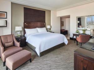 a hotel room with a large bed and a chair at Makkah Clock Royal Tower, A Fairmont Hotel in Makkah