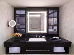 a bathroom with a sink and a mirror at Fairmont Singapore in Singapore