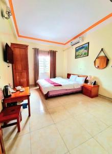a bedroom with a bed and a desk in it at Khách Sạn Mai Đào in Mèo Vạc